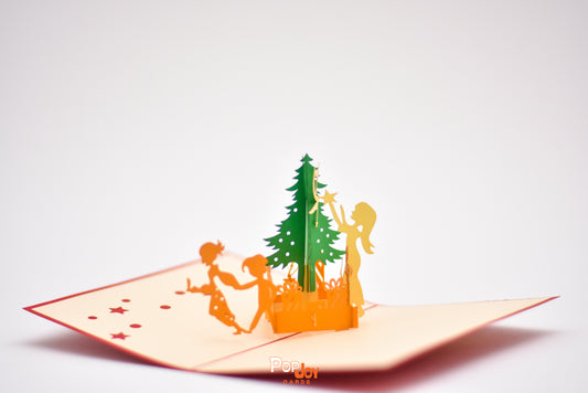 Pop-up card showing family decorating and playing around Christmas tree and gifts
