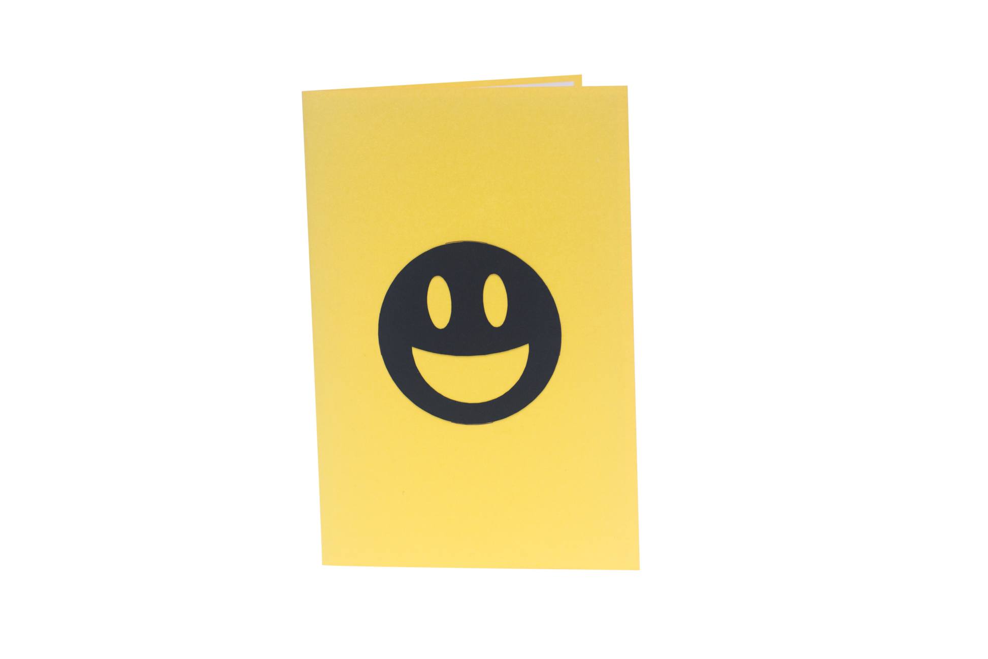 Yellow card with happy emoji in black on front cover
