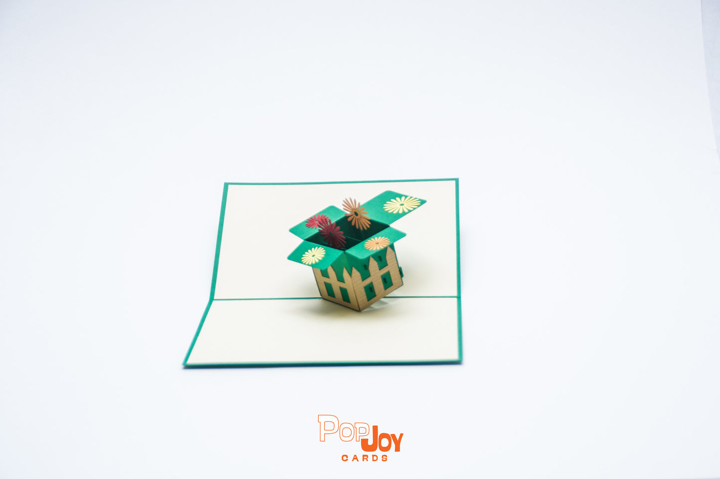 Pop-up card showing garden box lined with picket fence and filled with bright dandelions