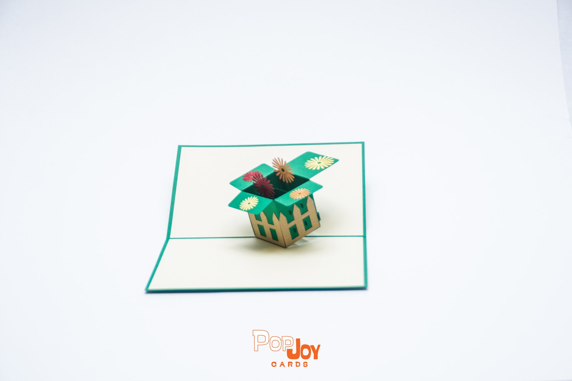 Pop-up card showing garden box lined with picket fence and filled with bright dandelions
