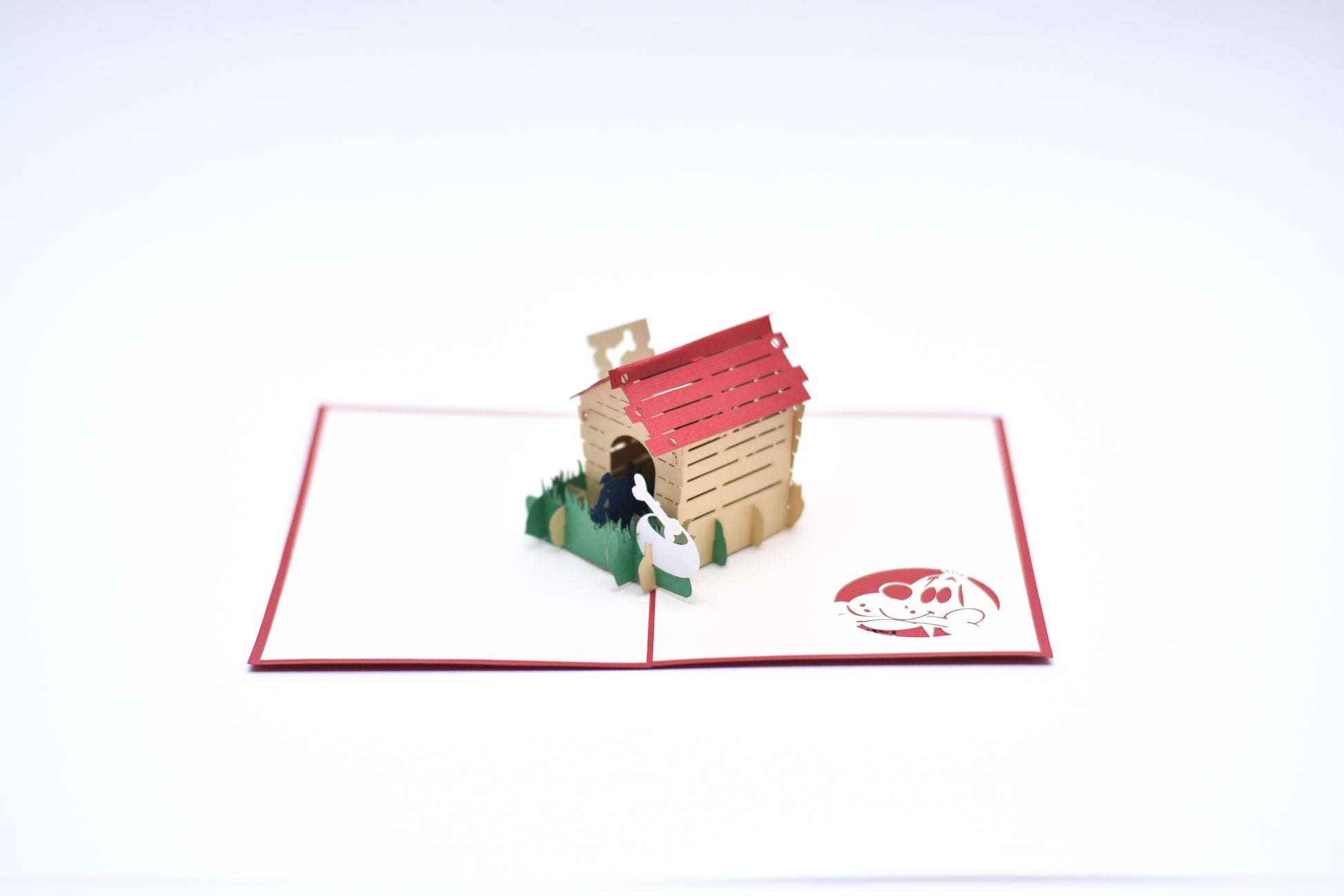 Pop-up card showing black dog inside his doghouse outside in the grass