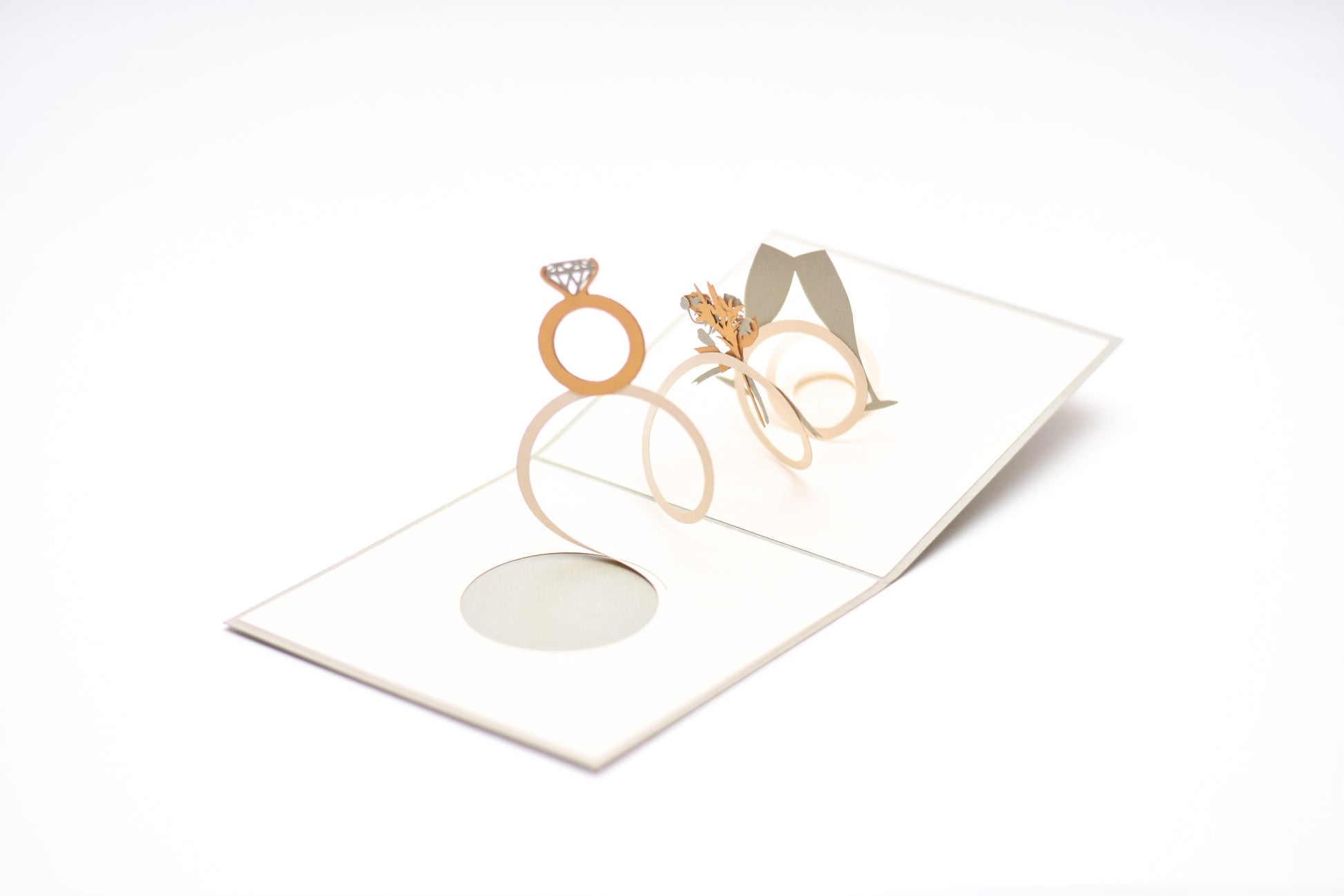 This white pop-up card opens up to a diamond gold ring, a bouquet of flowers and two glasses of champagne.