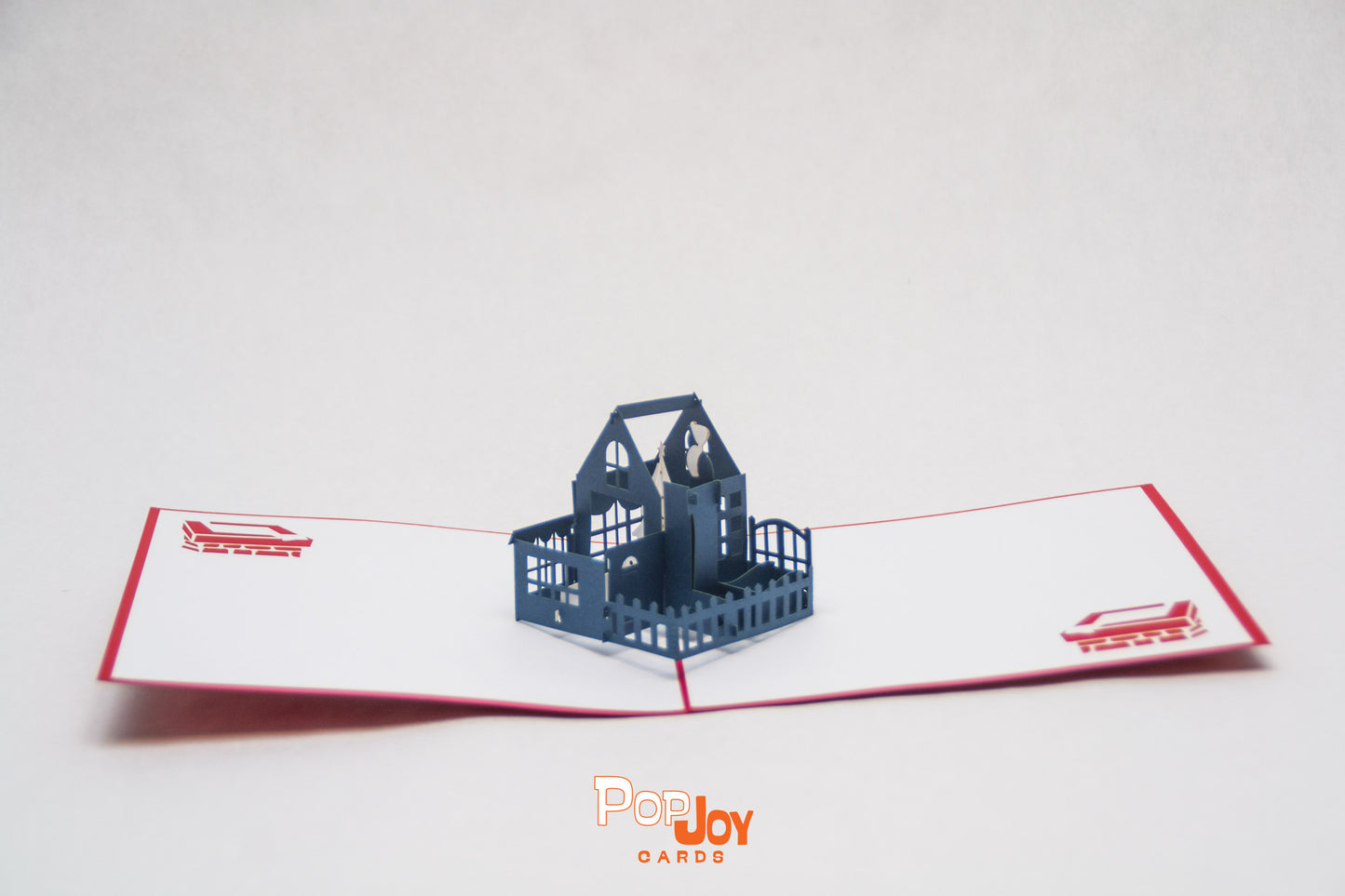 Pop-up card showing large blue house with white Christmas tree in top floor living room