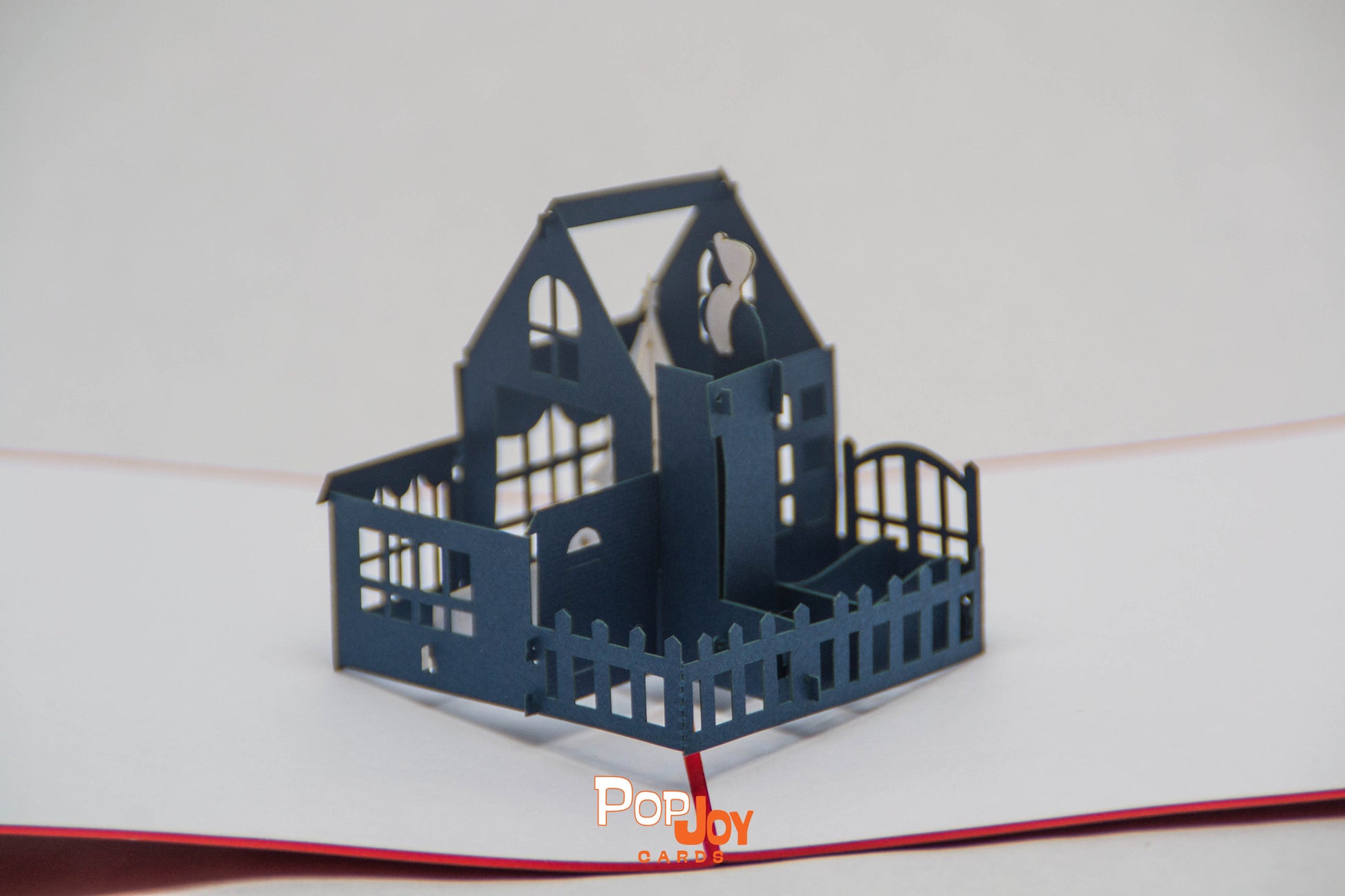 Closer picture of pop-up card showing large blue house with white Christmas tree in top floor living room