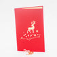 Red card with silhouette of reindeer, snow flakes and Merry Christmas on front cover