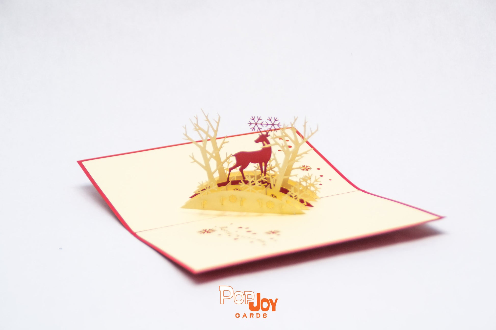 Pop-up card with red reindeer in the middle of light golden forest