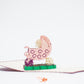 Pop-up card showing baby waving hello from pink stroller