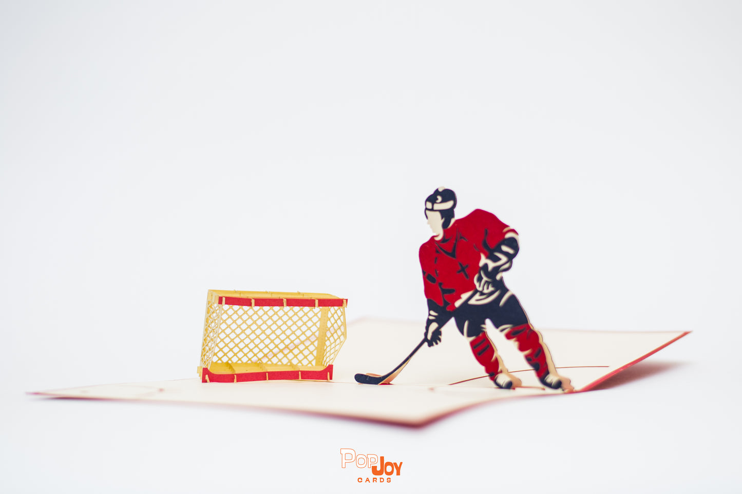 Pop-up card shows ice hockey player in red and blue about to shoot into the goalie net