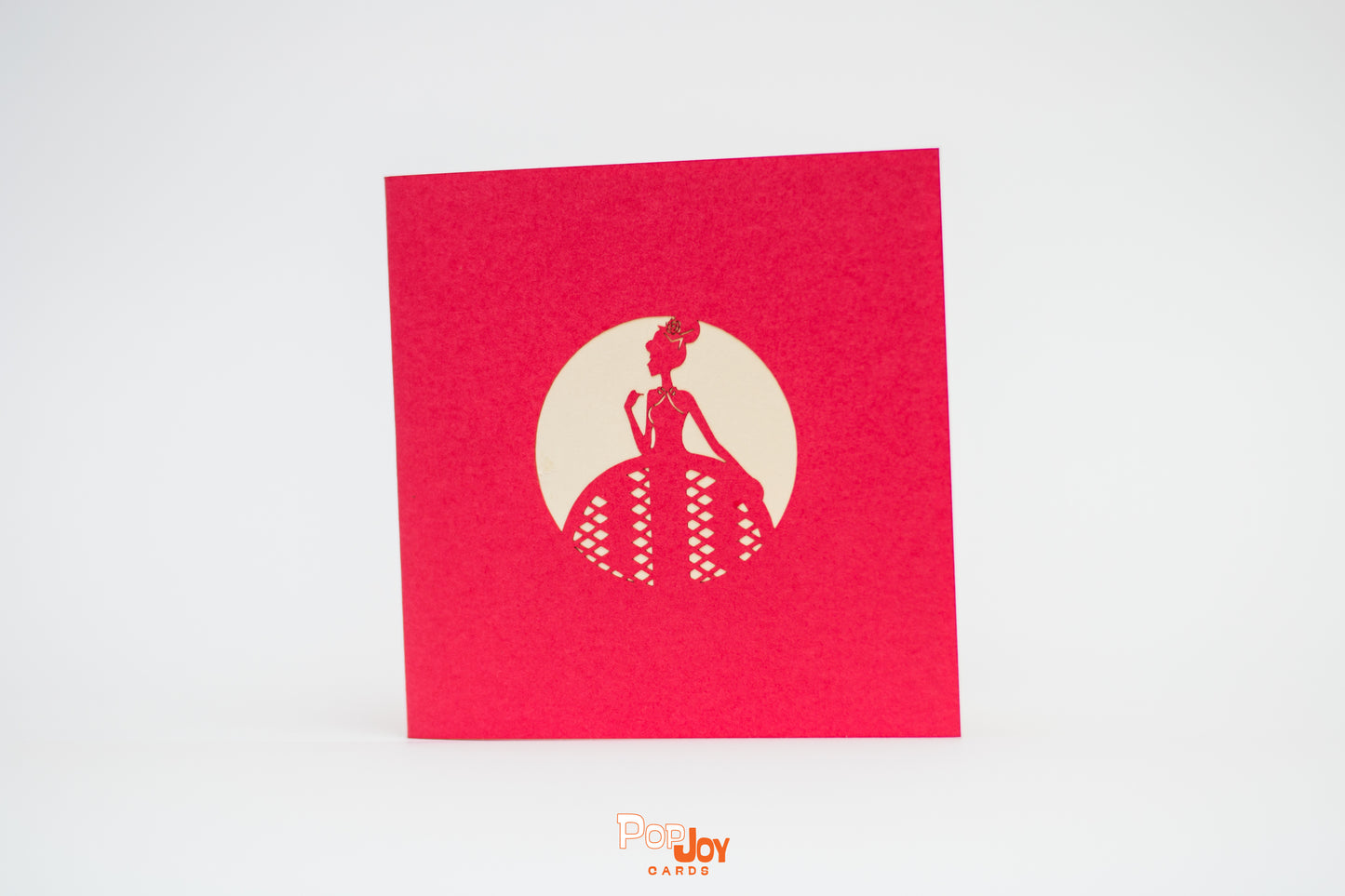 Red card showing silhouette of girl in ballgown against cream background on front cover
