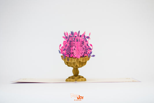 Pop-up card showing gold jardinière with pink and purple flowers 