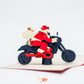 Pop-up card showing Santa riding his motorcycle, with a sack of toys on this back