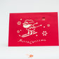 Red card with Santa skiing downhill and the words "merry Christmas"