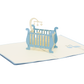 Pop-up card with blue cot and baby and playmobile in white cardstock