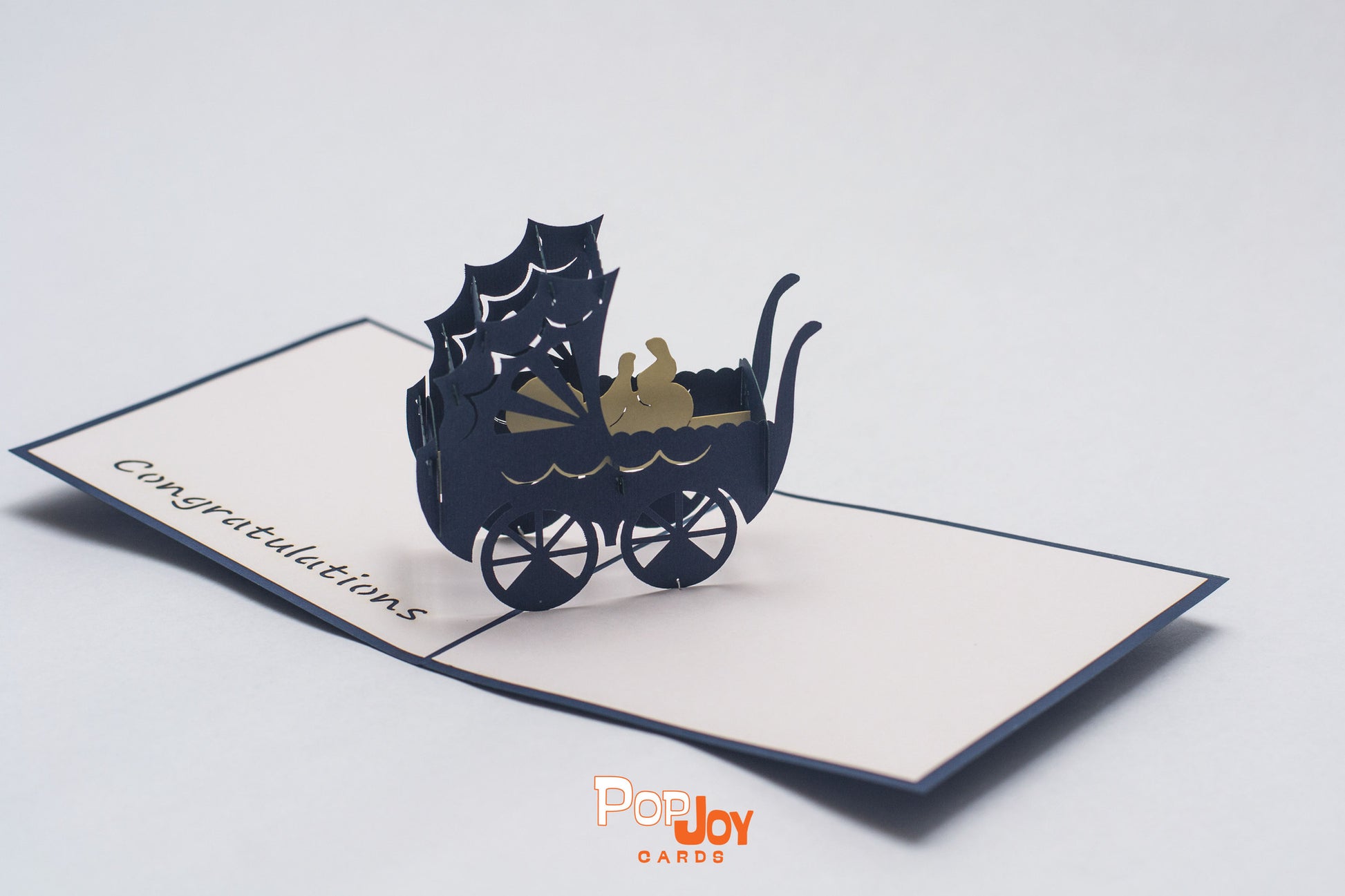 Pop-up card with 1950s style English stroller in dark blue with baby in white cardstock