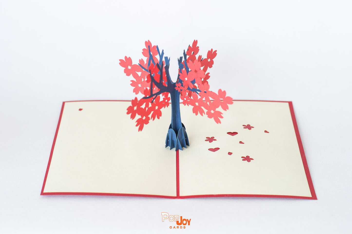 Pop-up card showing tree with big red flowers against cream card background