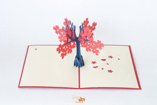 Pop-up card showing tree with big red flowers against cream card background