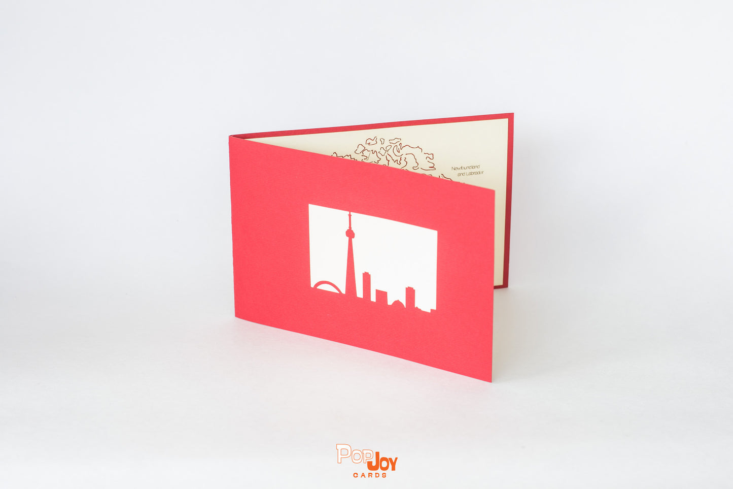 Red card with silhouette of Toronto skyline, including CN Tower in white