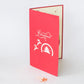 Red card with "Merry Christmas", snow globe with tree inside, and two reindeer in white on front cover