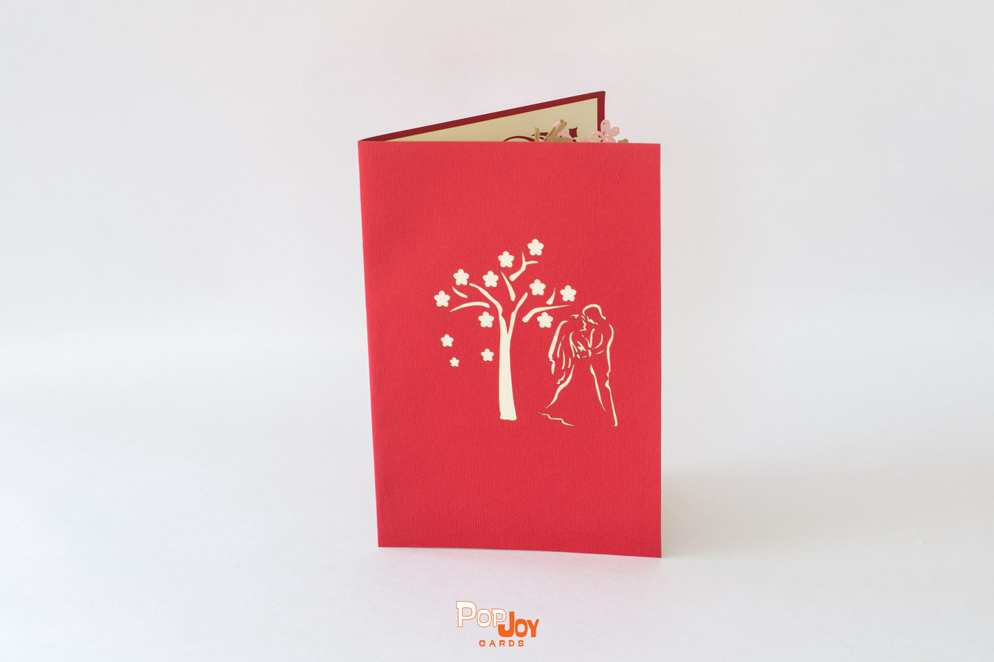 Red card showing cherry blossom tree and couple on wedding day