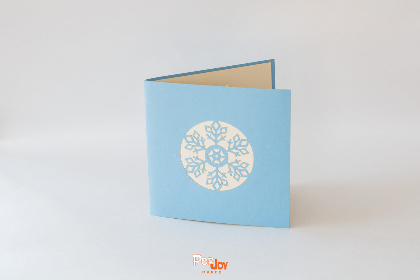 Blue card showing snowflake in white and blue on front cover