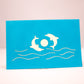 Blue card showing two dolphins playing with a ball on the front cover
